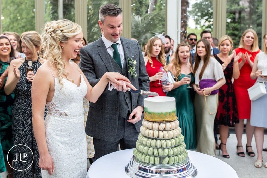 Natural wedding photography of the bride and groom cutting their cake by a Surrey wedding photographer.