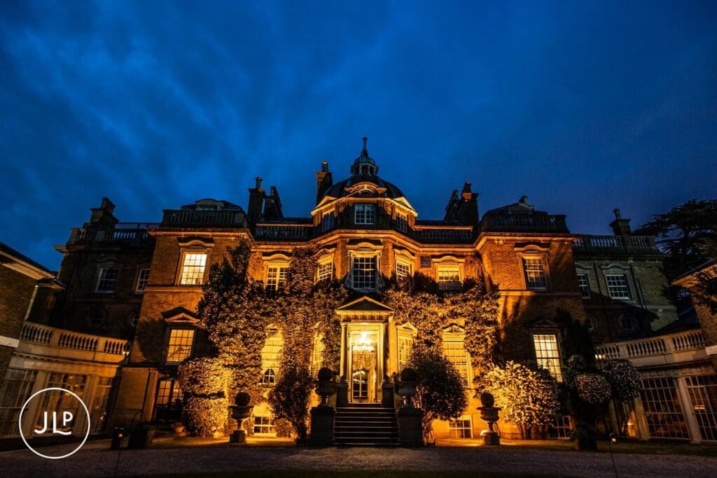 Stately exterior night view of an elegant Surrey wedding venue during Hampton Court House weddings.