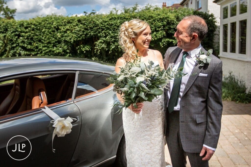 A bride and her dad outside by a London wedding photographer for a Hampton Court House wedding.