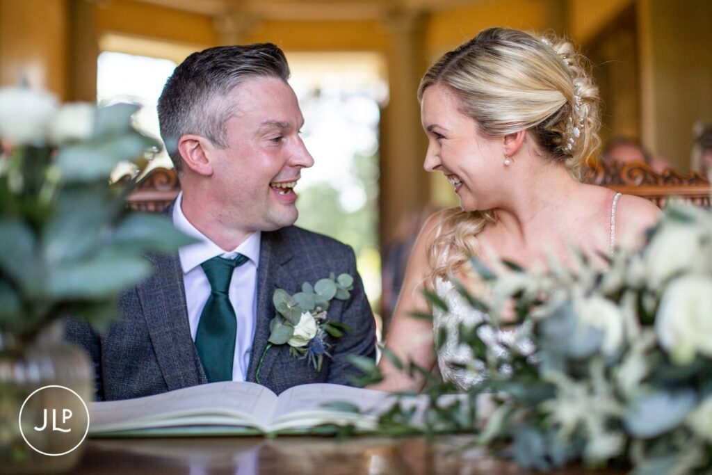 A bride and groom share a laugh during a relaxed wedding ceremony captured by a Surrey wedding photographer.
