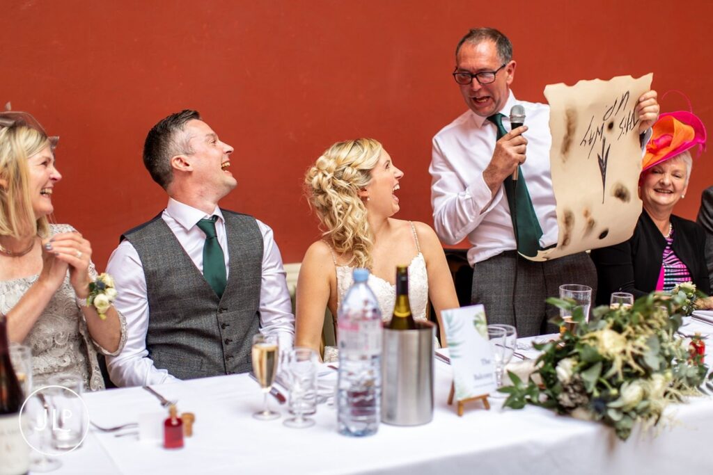 Documentary wedding photography of hilarious speeches at a beautiful Hampton Court House Surrey wedding.
