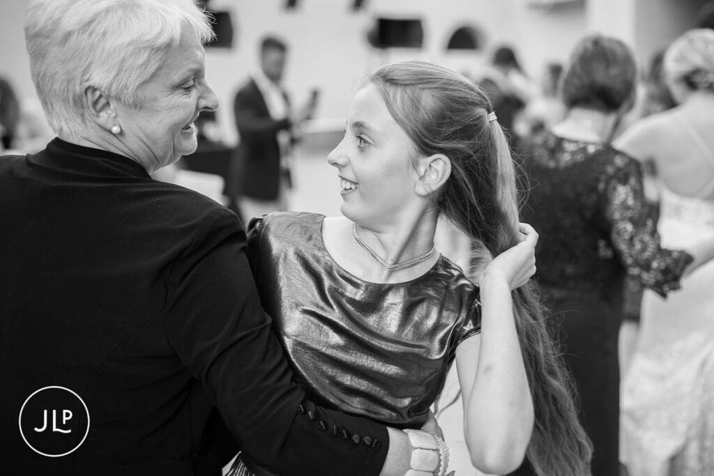 Natural wedding photography capturing emotional, candid moments between guests at a Hampton Court House wedding.