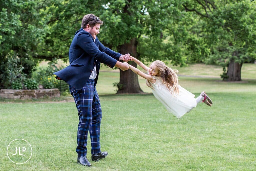 Candid wedding photography at Hampton Court House by a Surrey wedding photographer, capturing guests on the lawn.