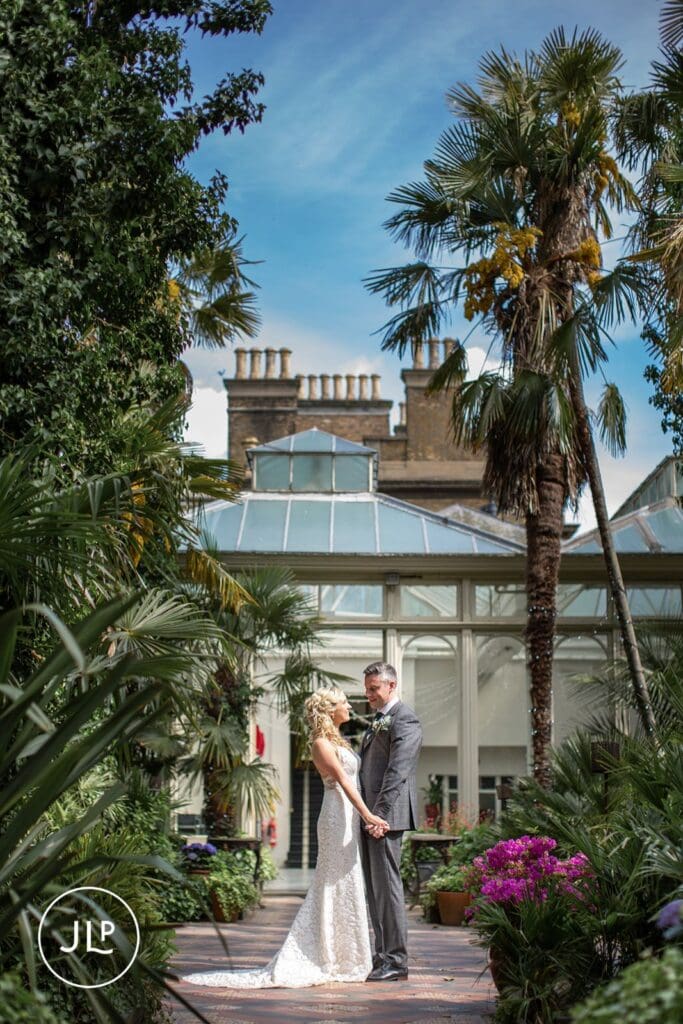 Bride and groom holding hands at a Hampton Court House wedding, captured by a expert Surrey wedding photographer.