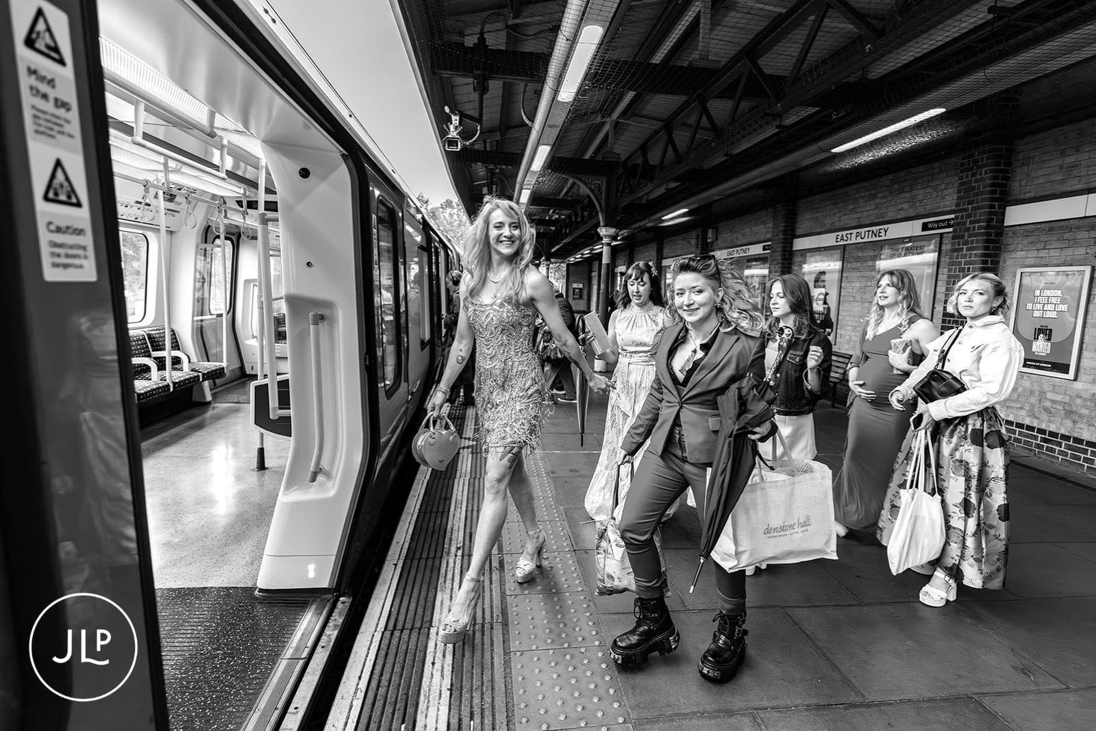 Bride and her wedding party boarding the train at East Putney station for a London wedding.