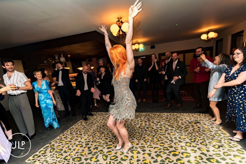 Fun London wedding photographer captures the bride dancing on a leopard print rug at a Hoxton Holborn wedding.