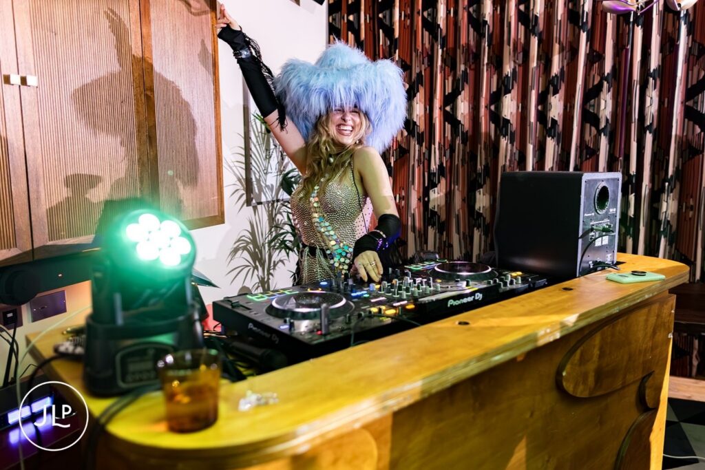 Fun London wedding photographer captures a DJ in a blue furry hat performing at a Hoxton Holborn wedding.