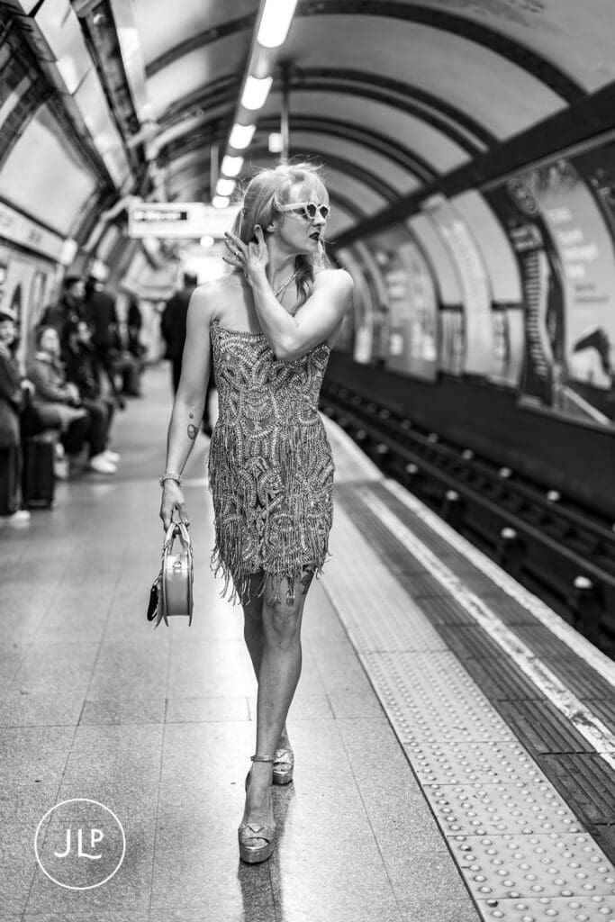 A black and white cinematic shot of a bride walking through a Central London Tube station.