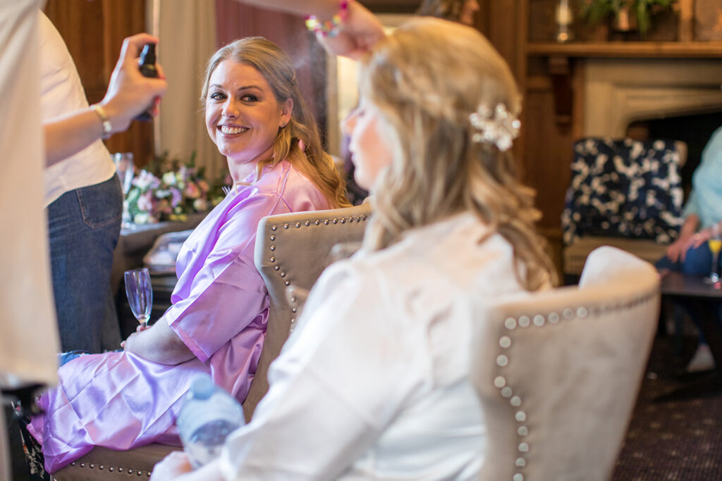 Natural wedding photography Surrey of a bride smiling during morning preparations at Langshott Manor.