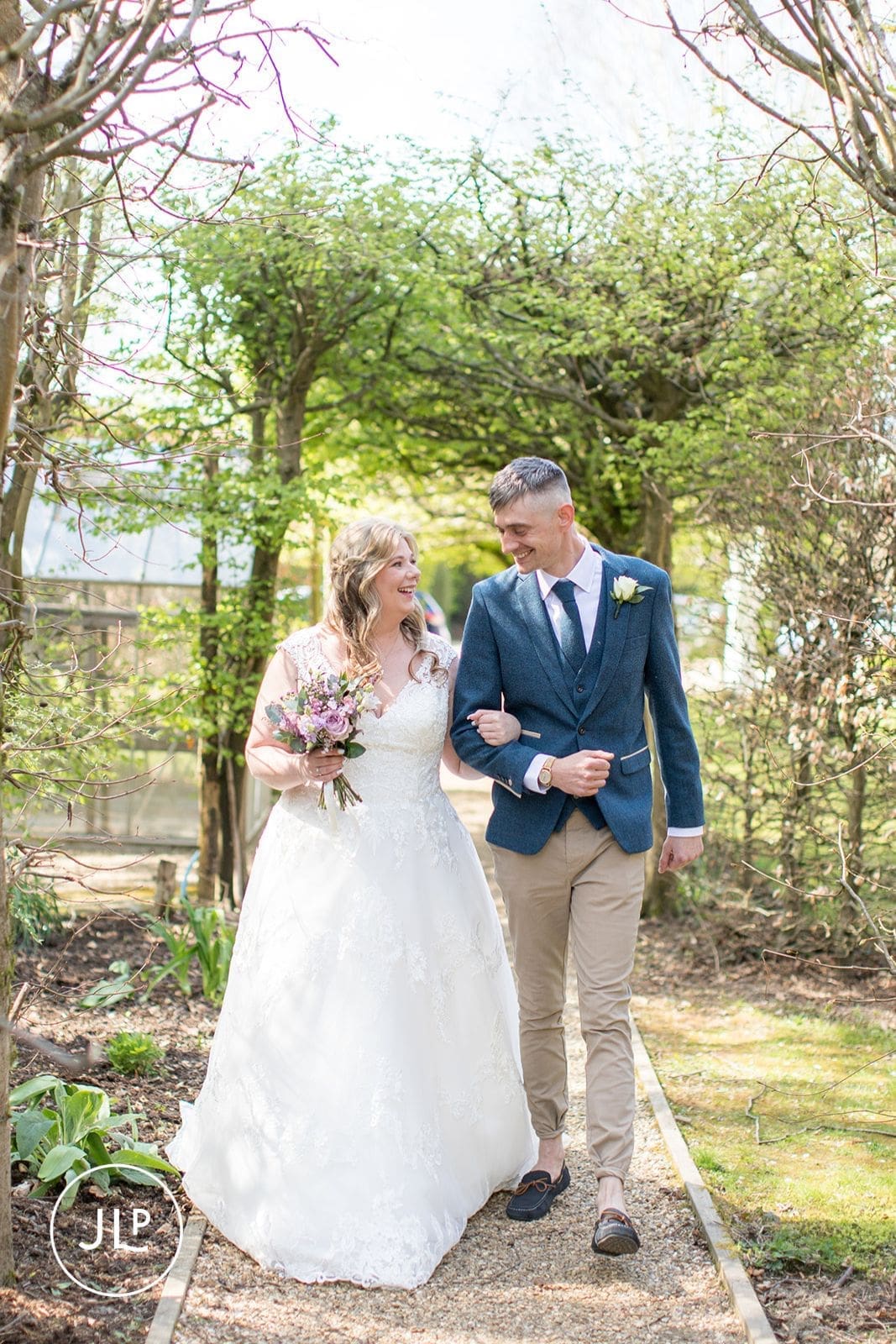 Couple enjoying natural wedding photography walking in Langshott Manor's picturesque gardens.