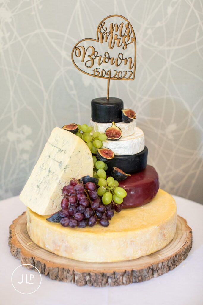 A unique wedding cake made of tiered local cheeses, decorated with figs and grapes for a wedding.