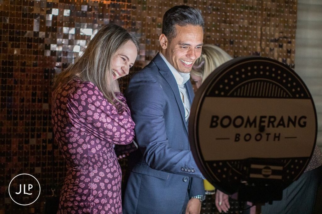 Guests having fun and laughing at a modern Boomerang photo booth during a Surrey wedding party.