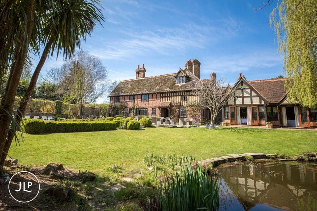 Scenic view of the gardens and pond at Langshott Manor, a boutique Surrey wedding venue.
