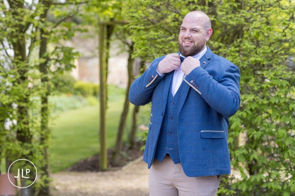 Groom in a blue tweed suit at Langshott Manor, captured by a Surrey wedding photographer.