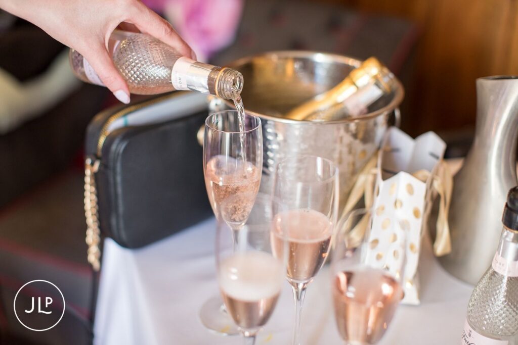 Candid moment of pouring champagne at Langshott Manor, an award-winning Surrey wedding venue.