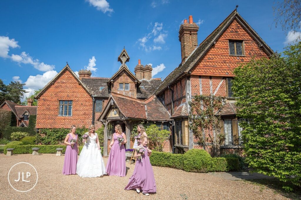 Bride and bridesmaids outside Langshott Manor, a historic Tudor wedding venue Surrey.