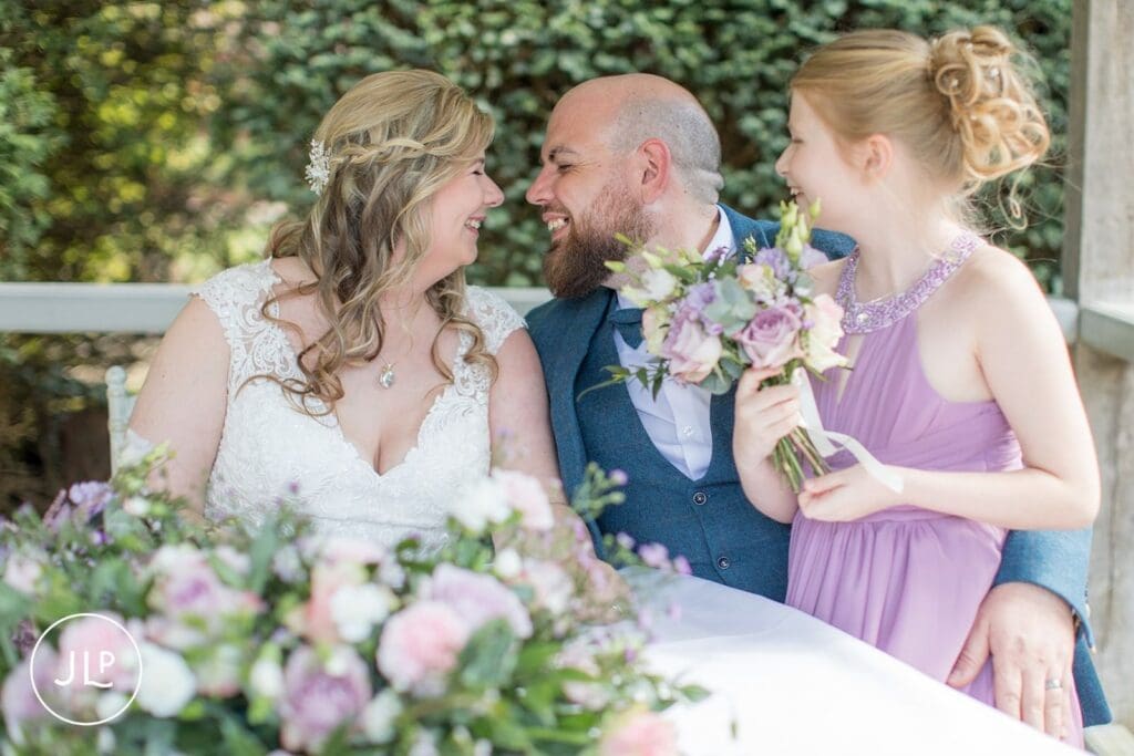 Candid moment with the bride, groom, and flower girl at Langshott Manor wedding venue Surrey.