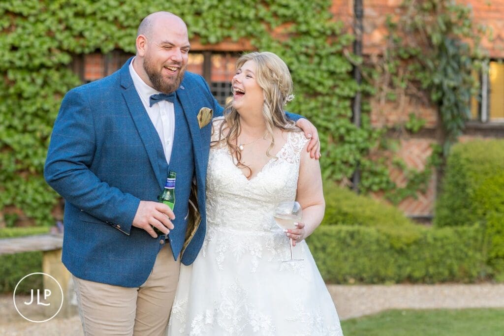 Bride and groom laughing during their reception at Langshott Manor, a beautiful Tudor wedding venue Surrey.