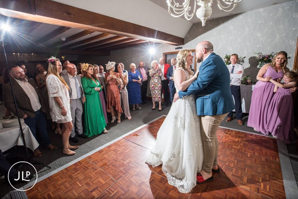 The newlyweds sharing their romantic first dance on the wooden dance floor at their Surrey wedding venue.