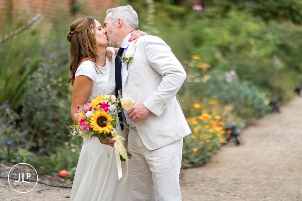 Newlyweds kissing during their Painshill Park wedding, by a professional Painshill Park wedding photographer.