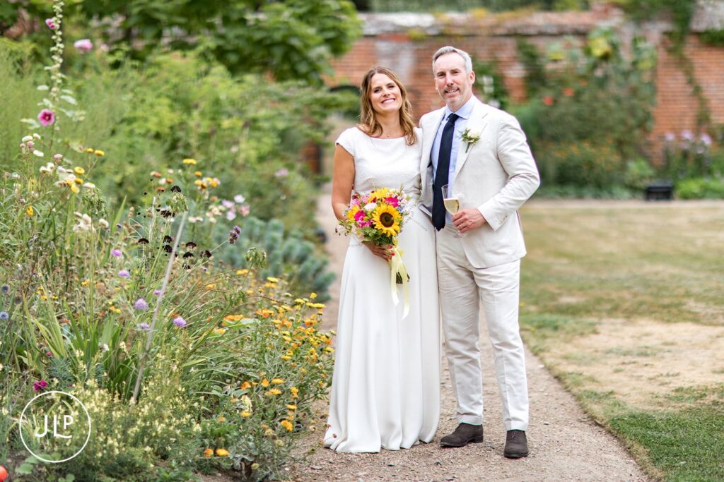 Newlyweds walking through a meadow, captured by a professional Painshill Park wedding photographer.