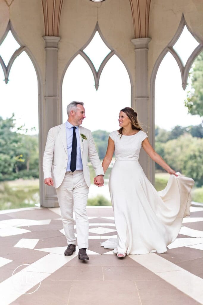 Bride and groom walking during their relaxed outdoor Surrey wedding at Painshill Park Cobham.