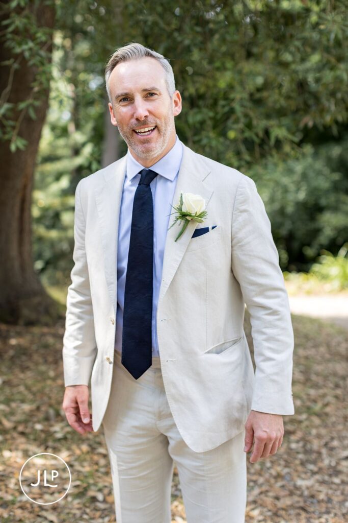 Portrait of a groom in a beige suit, captured by a professional Painshill Park wedding photographer.