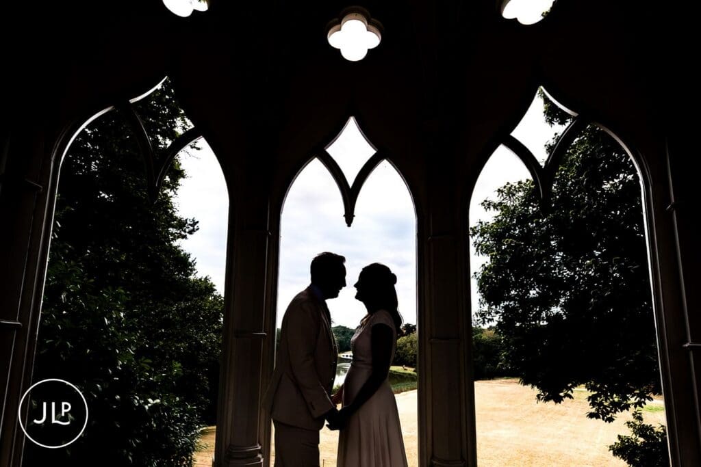 Stunning silhouette portrait of a bride and groom inside the Gothic Temple at a Painshill Park wedding.