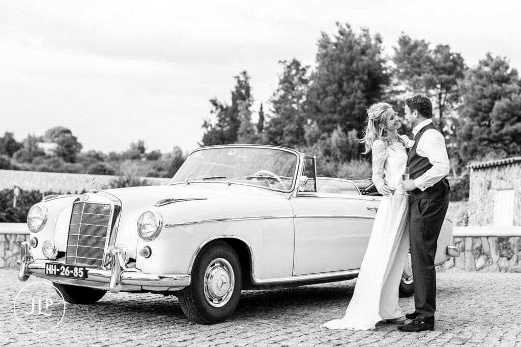 Black and white wedding portrait by a vintage Mercedes, shot by a Quinta dos Vales wedding photographer.