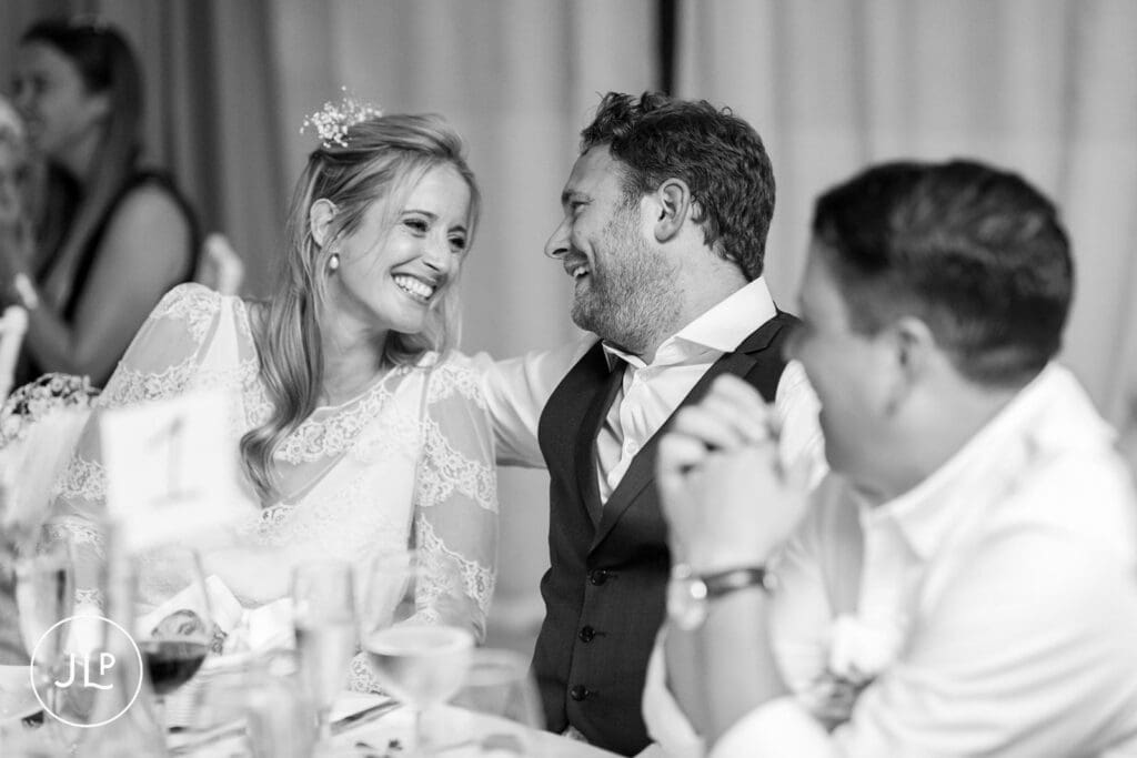 Ali and Matty sharing a laugh at their top table during a destination wedding breakfast in Portugal.