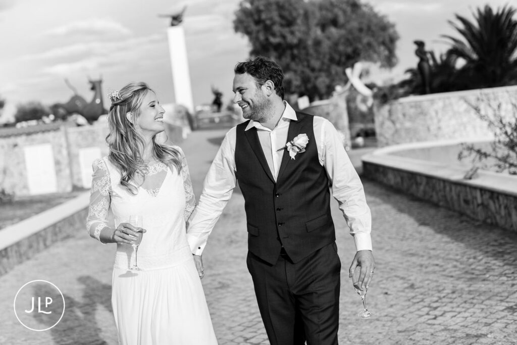 Candid B&W moment of the couple laughing at their Algarve vineyard wedding celebration in Portugal.