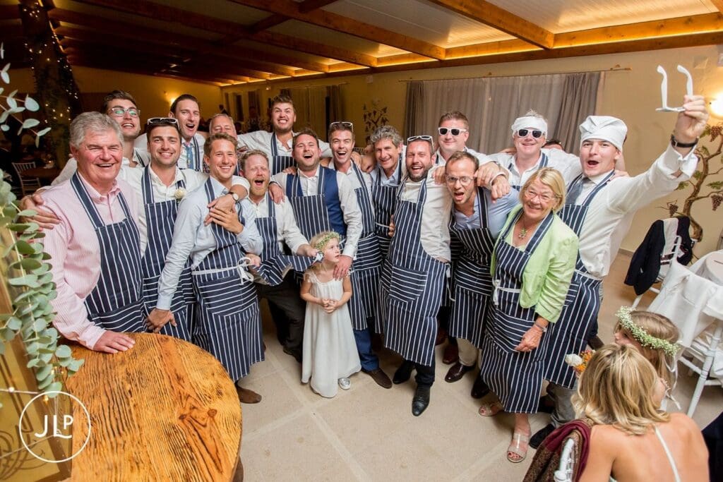 Table hosts in chef hats and aprons at a fun Quinta dos Vales wedding feast, shot by an Algarve wedding photographer.