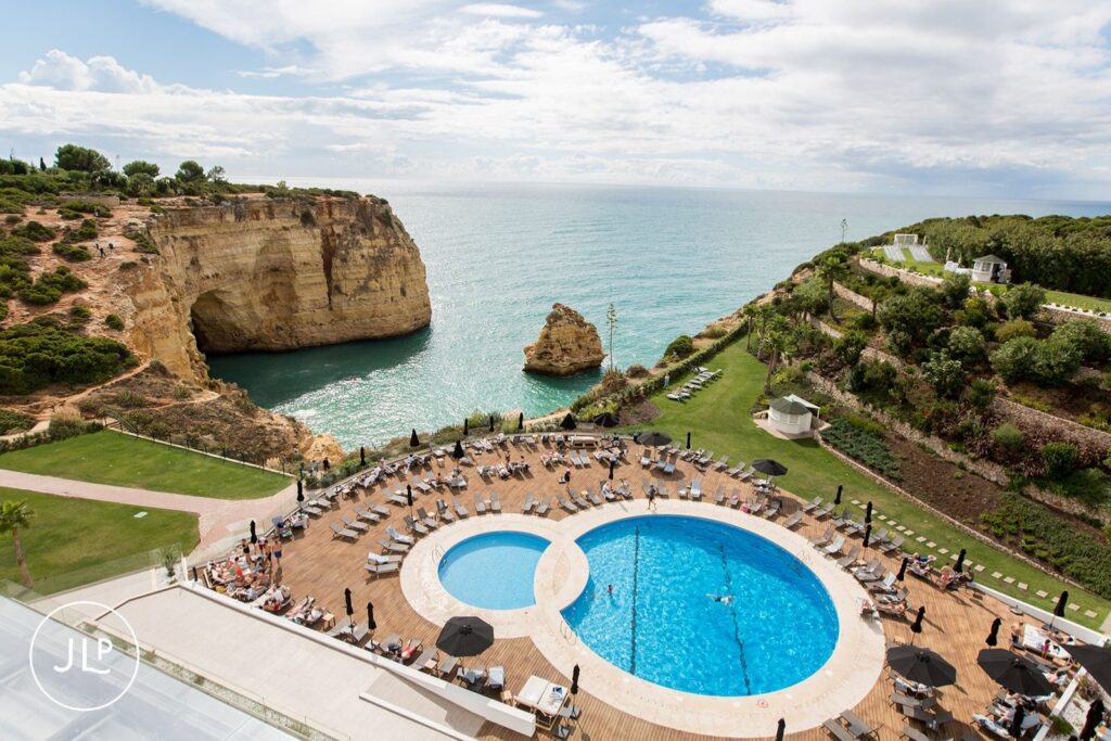 View of the Tivoli Carvoeiro pool and dramatic Atlantic cliffs from a destination wedding photographer in Portugal.