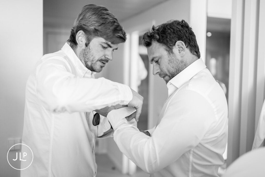 Groomsman helping Matty with his cufflinks during luxury destination wedding preparations in the Algarve.