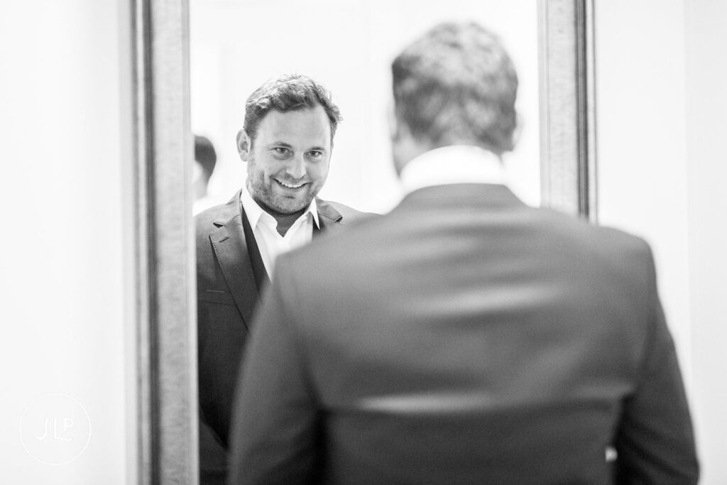 B&W portrait of Matty checking his reflection, a natural moment by a Quinta dos Vales wedding photographer.