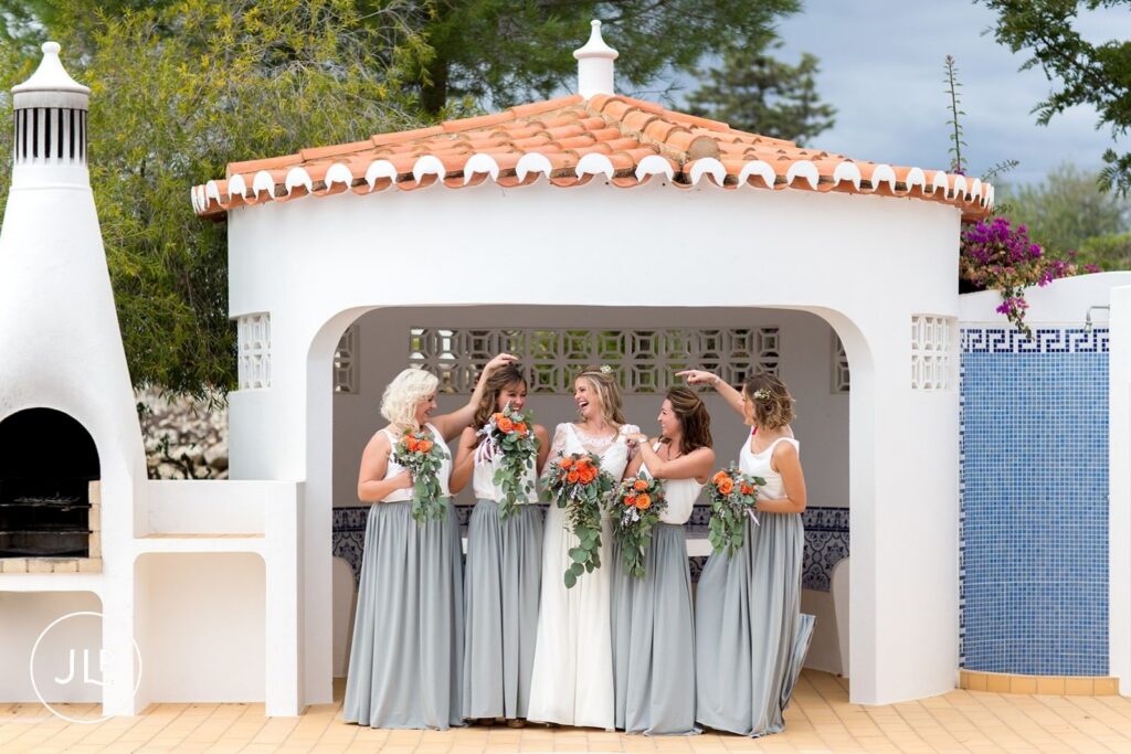Ali and her bridesmaids laughing outside a white villa, captured by a Quinta dos Vales wedding photographer.