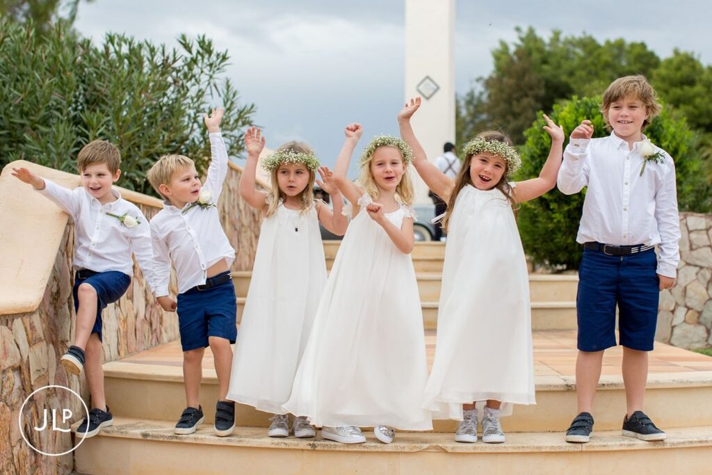 Page boys and flower girls cheering on the steps, captured by a Portugal destination wedding photographer.