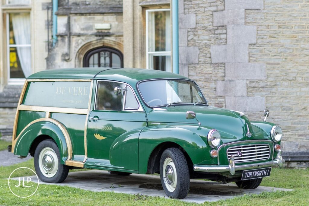 A classic green vintage Morris Minor van parked outside a luxury Gloucestershire wedding venue.