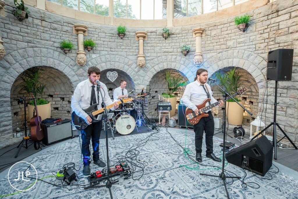 A three-piece wedding band performing live in the Orangery for De Vere Tortworth Court wedding photography.