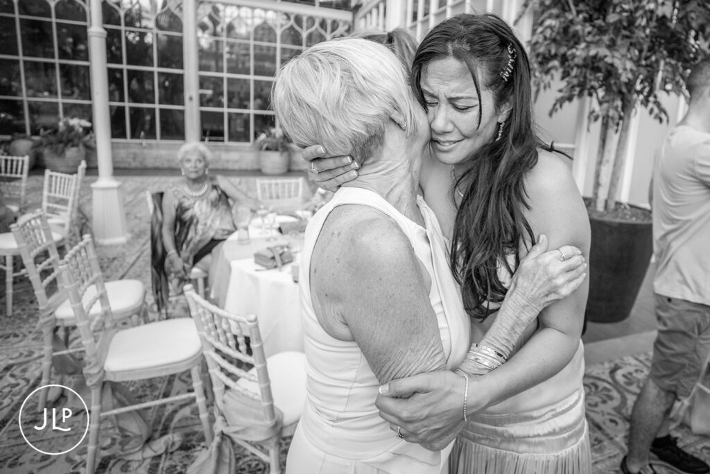A heartfelt hug between the bride and a guest, a signature shot by a candid wedding photographer UK.