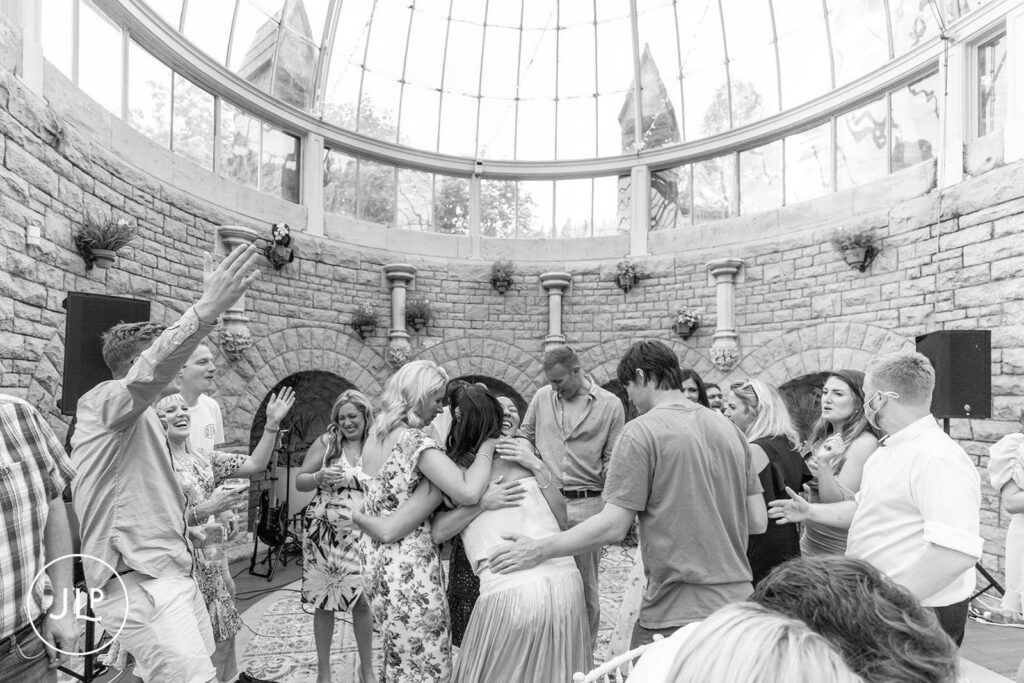 Friends and family surrounding the bride on the dance floor during a luxury Gloucestershire wedding.