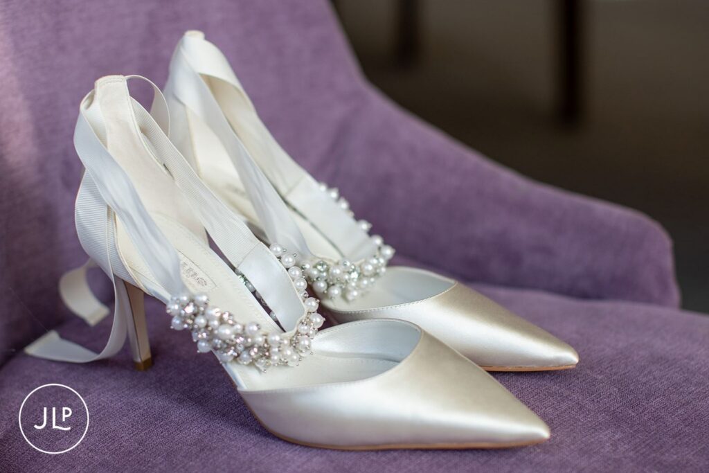Elegant white satin bridal heels with pearl and crystal details for a luxury Gloucestershire wedding.