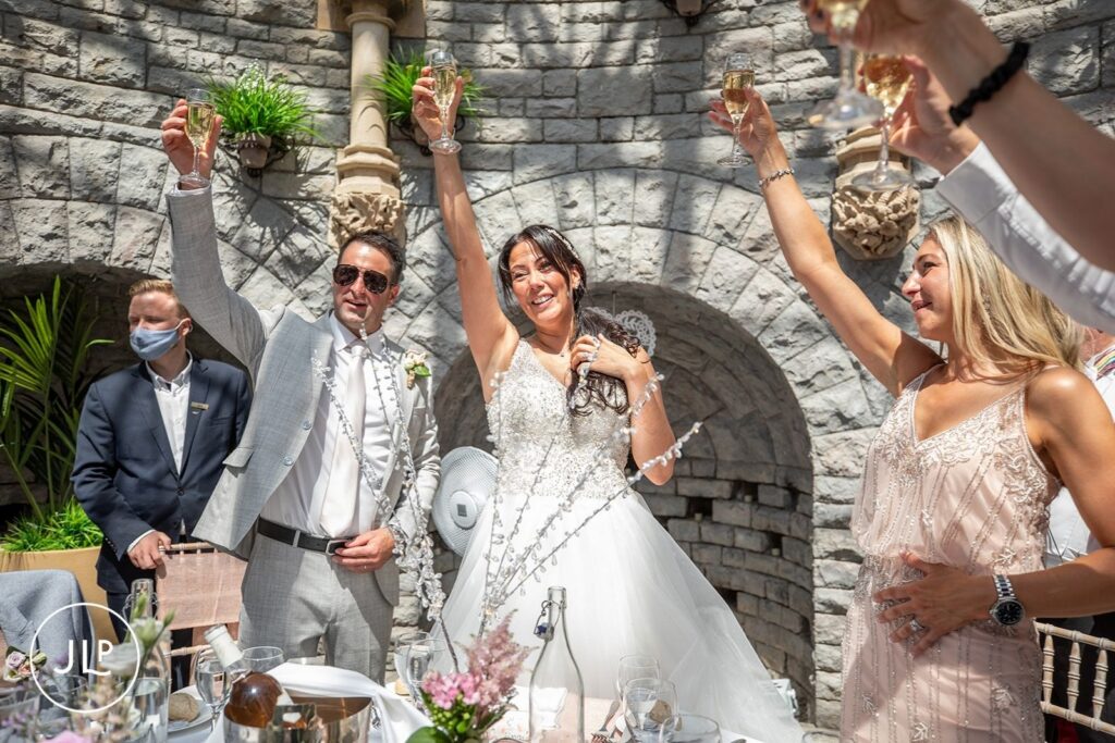 Mel and Ben toast with guests during their De Vere Tortworth Court wedding photography session.