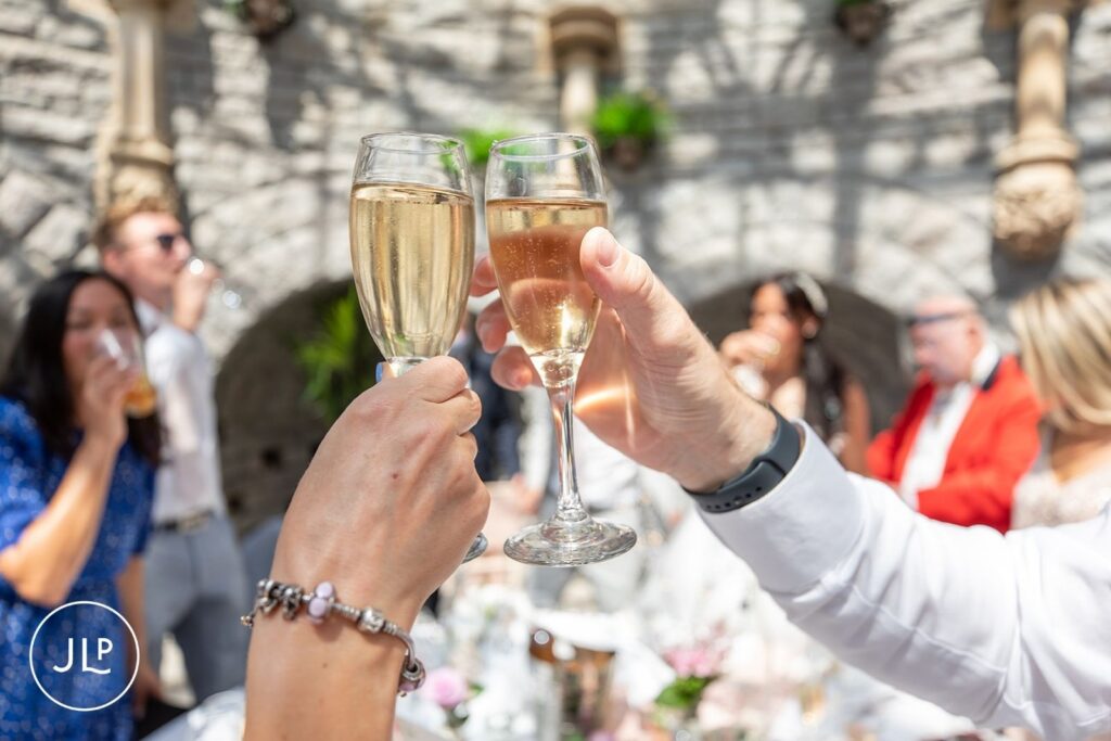 Guests raising a glass for a champagne toast, featuring natural wedding photography Gloucestershire style.