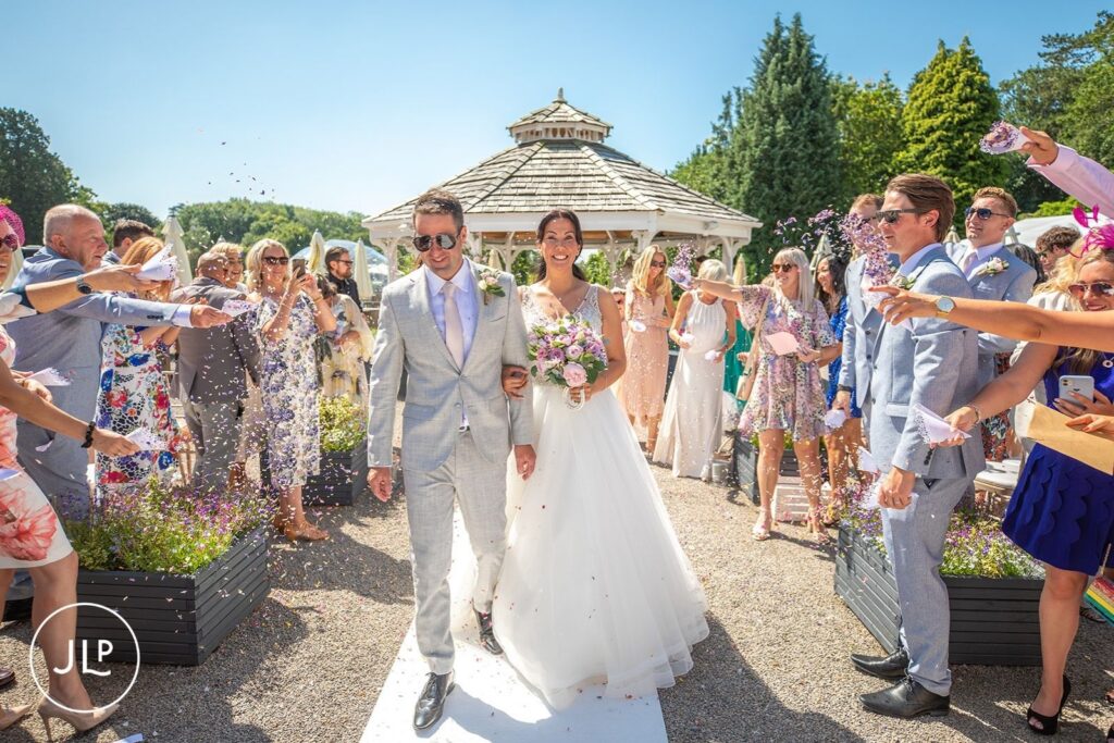 Confetti moment for Mel and Ben at their outdoor wedding at De Vere Tortworth Court.