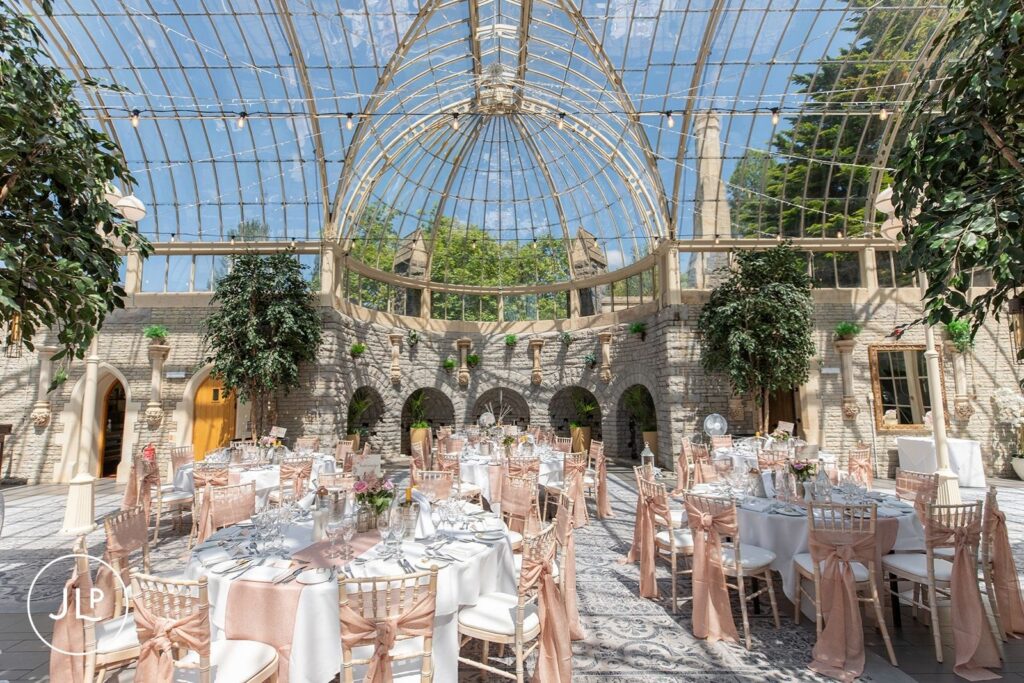 Elegant reception tables with blush sashes in the Orangery at De Vere Tortworth Court.