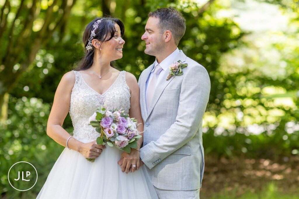 Bride and groom sharing a romantic look in the gardens during De Vere Tortworth Court wedding photography.