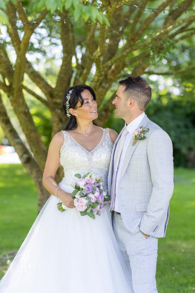 Mel and Ben sharing a quiet moment on the sweeping lawns, a signature style of a Wotton-under-Edge wedding photographer.
