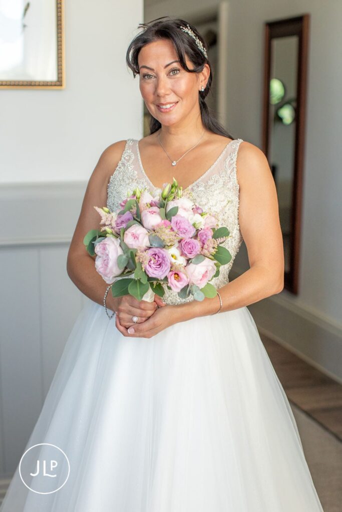 Radiant bride Mel holding her bouquet, a beautiful moment from a Wotton-under-Edge wedding photographer.