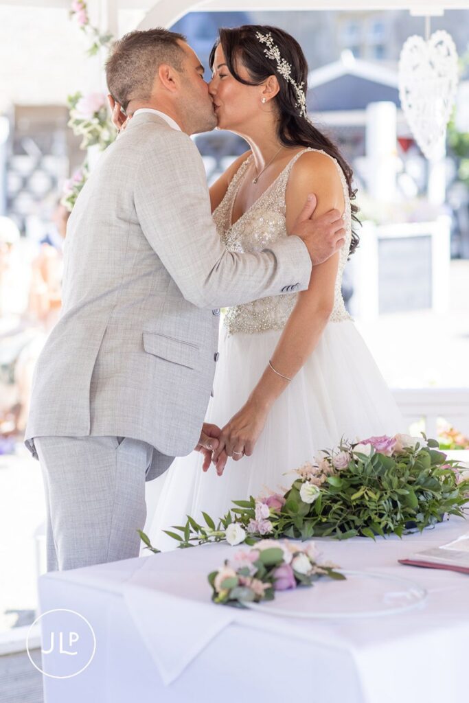 Romantic first kiss at De Vere Tortworth Court, captured by a candid wedding photographer UK.